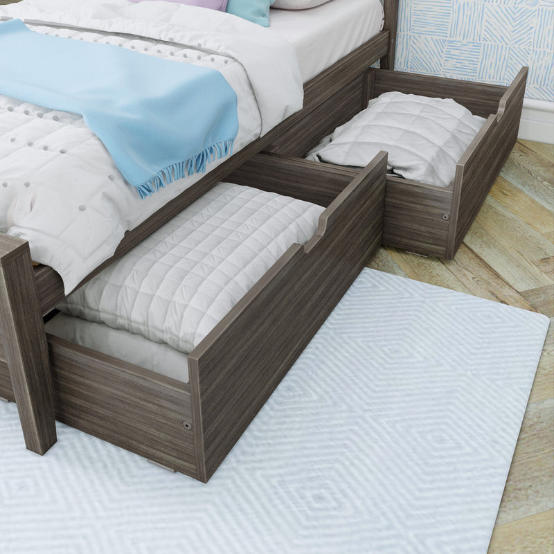 Grey wood twin trundle bed with two pull-out underbed storage drawers, white quilted bedding and light blue throw, ideal for kids' bedroom