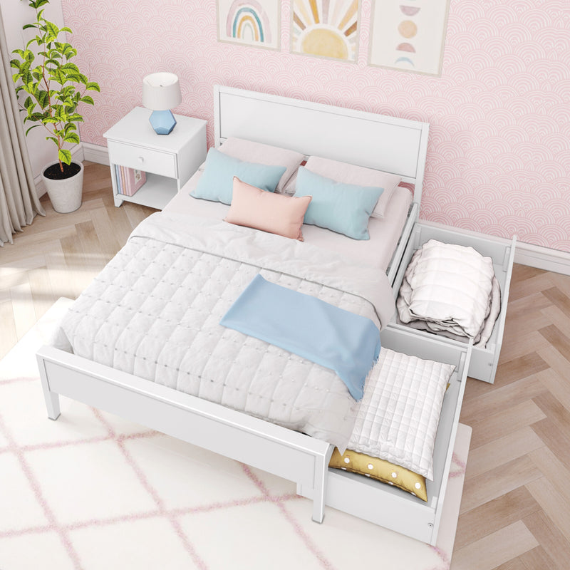 Pastel girls bedroom with white wooden bed and pull-out storage drawers, pink scallop wallpaper, pastel pillows, white nightstand with blue lamp and potted plant on herringbone wood floor