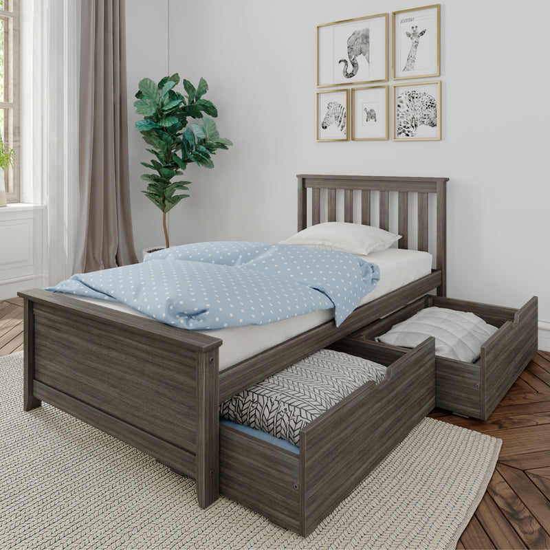 Gray wooden twin bed with pull-out under-bed storage drawers, blue polka-dot duvet, indoor fiddle-leaf fig and framed animal prints in a bright minimalist kids' bedroom