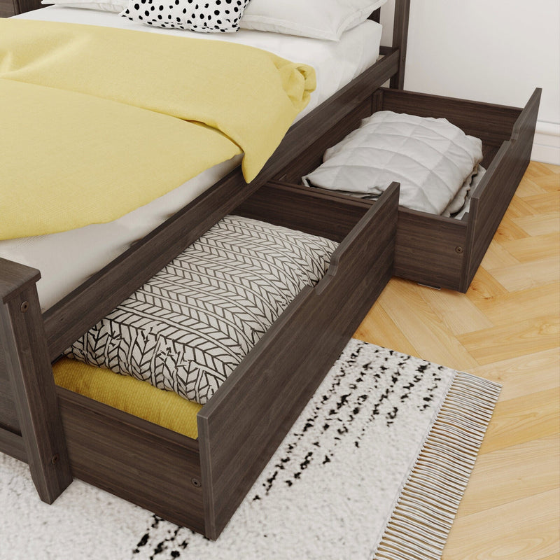 Dark wood platform bed with under-bed storage drawers open, yellow duvet, patterned pillows and folded blankets on hardwood floor