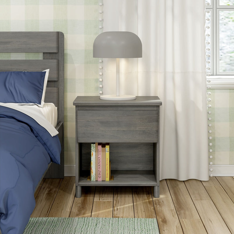 Grey wooden nightstand with modern dome lamp beside bed with blue bedding, books on lower shelf, white curtains, plaid wallpaper and hardwood floor