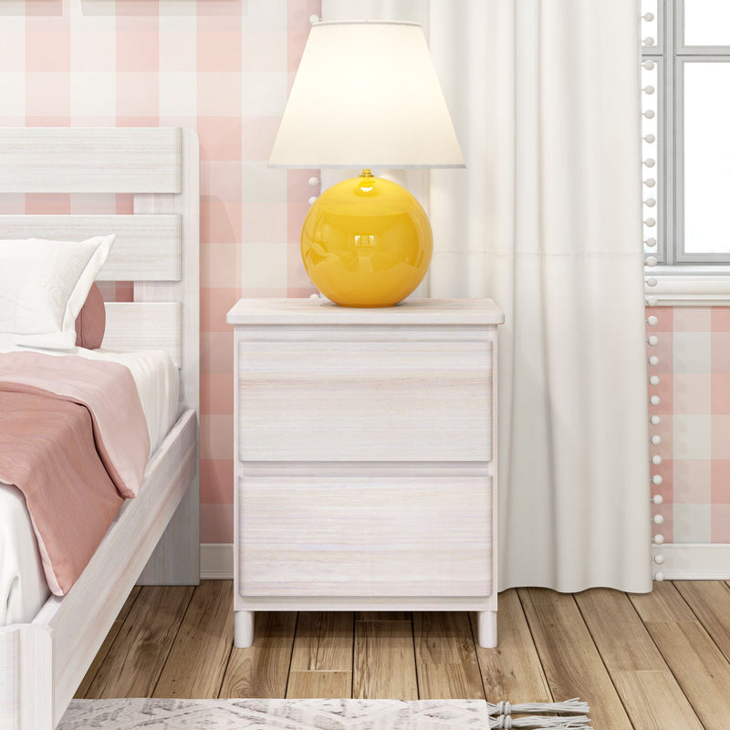 Yellow ceramic table lamp on white wood nightstand beside bed with pink gingham wallpaper, pastel pink bedding, white curtains and hardwood floor