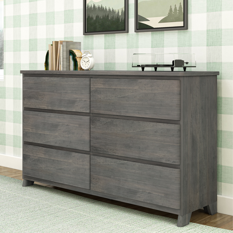 Gray wooden six-drawer dresser with rustic finish in bedroom styled with green plaid wallpaper, books, white alarm clock and vinyl record player