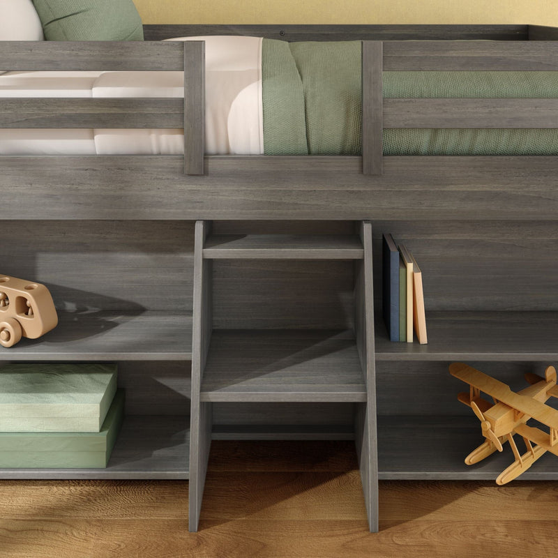 Gray wooden loft bunk bed with built-in storage shelves and ladder, green bedding, wooden toy airplane and stacked boxes in kids bedroom