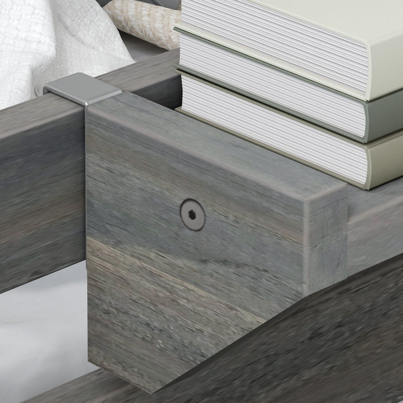 Close-up of gray weathered wooden platform bed frame corner with metal bracket and stacked hardcover books, modern rustic bedroom decor detail