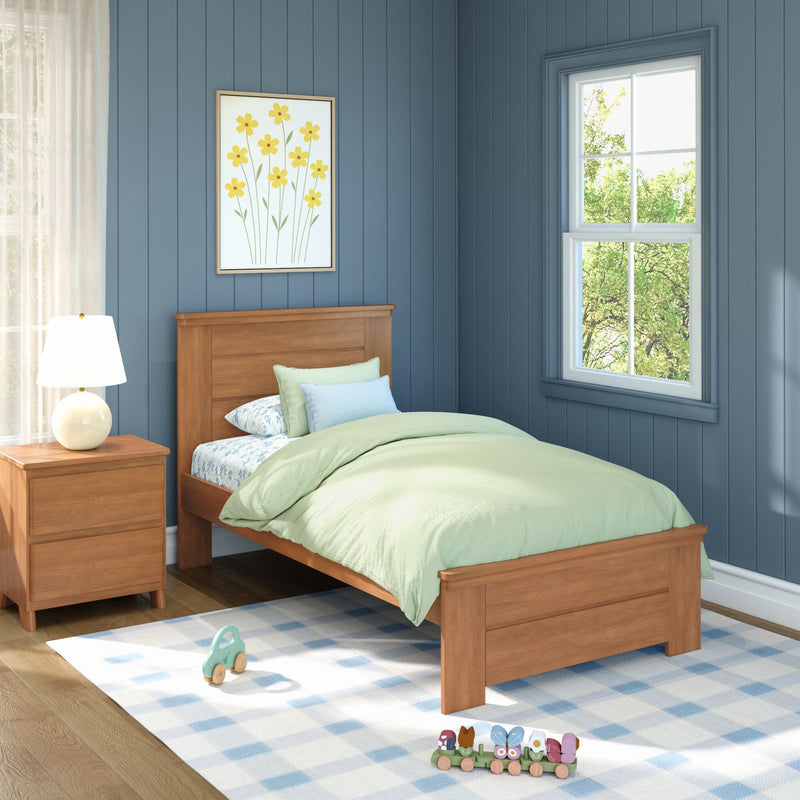 Kids bedroom with wooden twin bed, pastel green bedding, blue paneled walls, bedside lamp, framed yellow flower art, sunny window and toys on rug