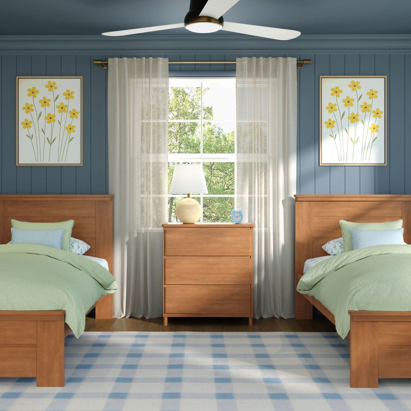 Twin bedroom with wooden beds, green bedding, blue shiplap wall, sheer curtains, lamp, blue alarm clock, ceiling fan