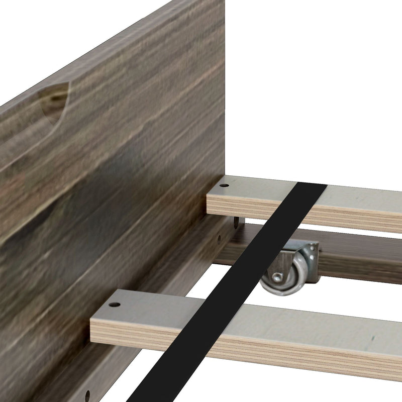 Close-up of wooden bed frame plywood slats with black metal center support strap and caster wheel under middle support near rustic wooden headboard