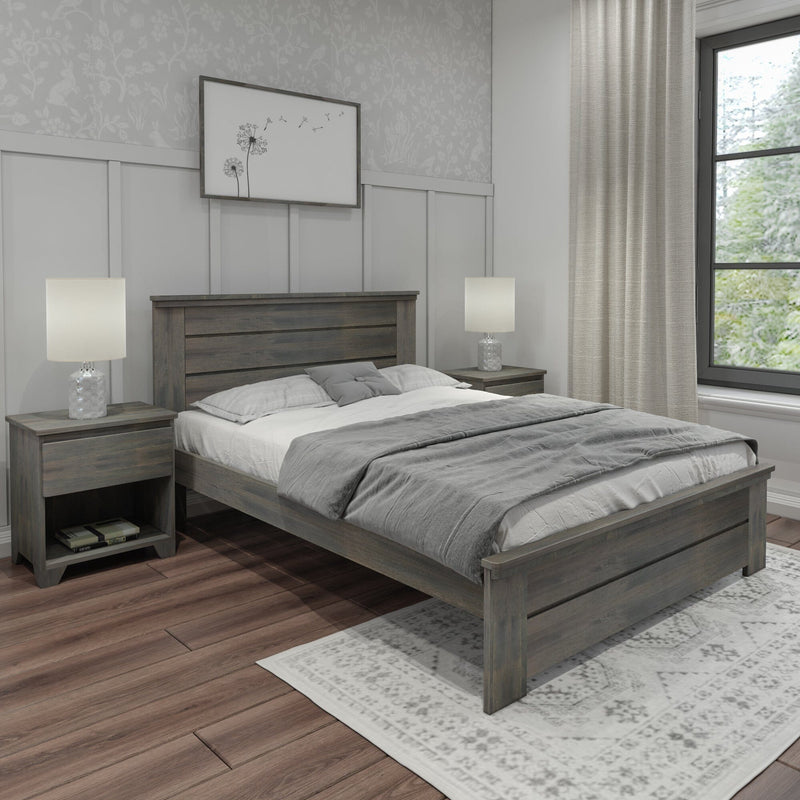 Modern farmhouse bedroom with grey wood bed frame and nightstands, neutral bedding, table lamps, textured curtains, framed dandelion wall art, wood plank floors and patterned area rug