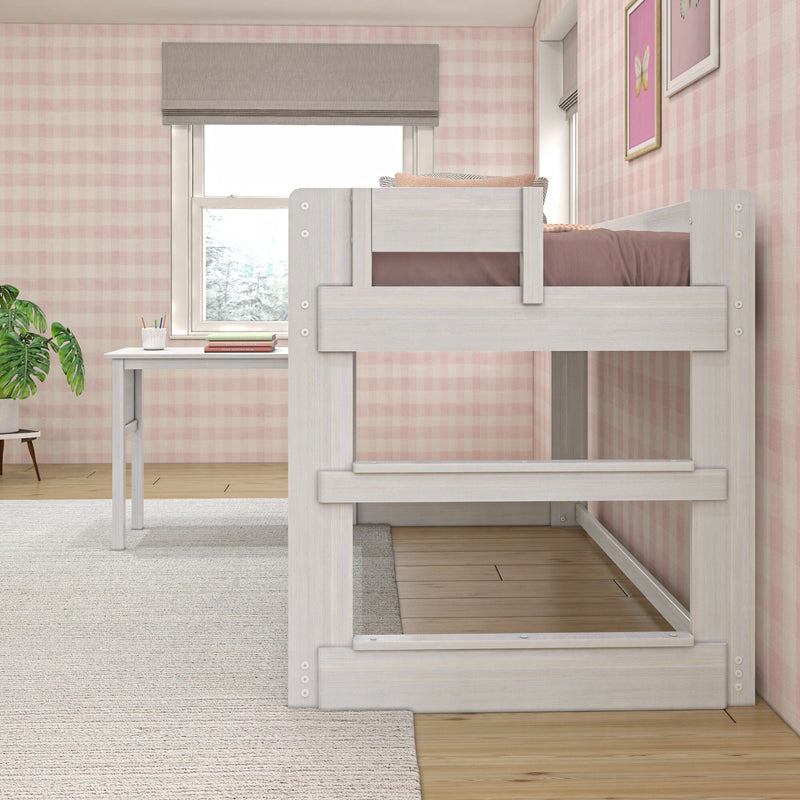 White wooden loft bunk bed and study desk in a child's bedroom with pink gingham wallpaper, window shade and houseplant