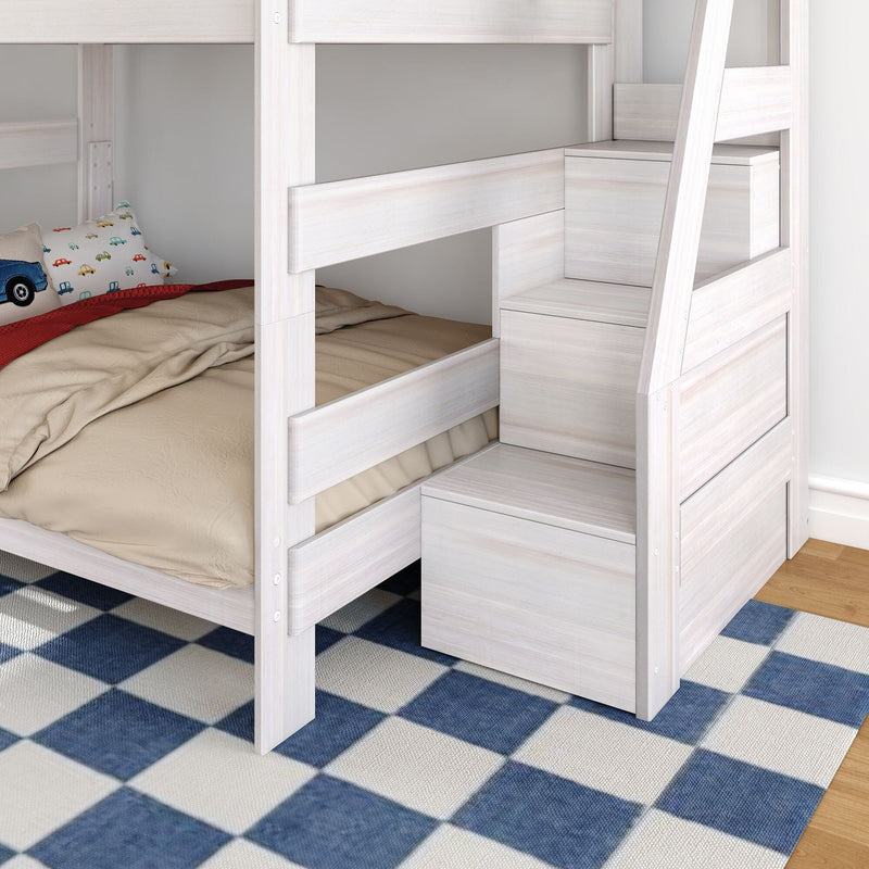 Whitewashed wooden bunk bed with built-in storage stairs and drawers, beige bedding and car-print kids pillow on lower bunk, space-saving children's bedroom on blue checkered rug