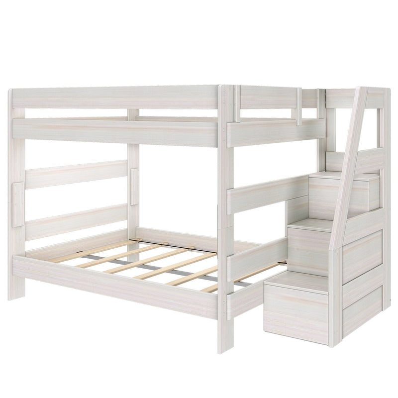 Whitewashed wooden twin-over-full bunk bed frame with safety rails, slatted mattress supports and staircase with built-in storage drawers