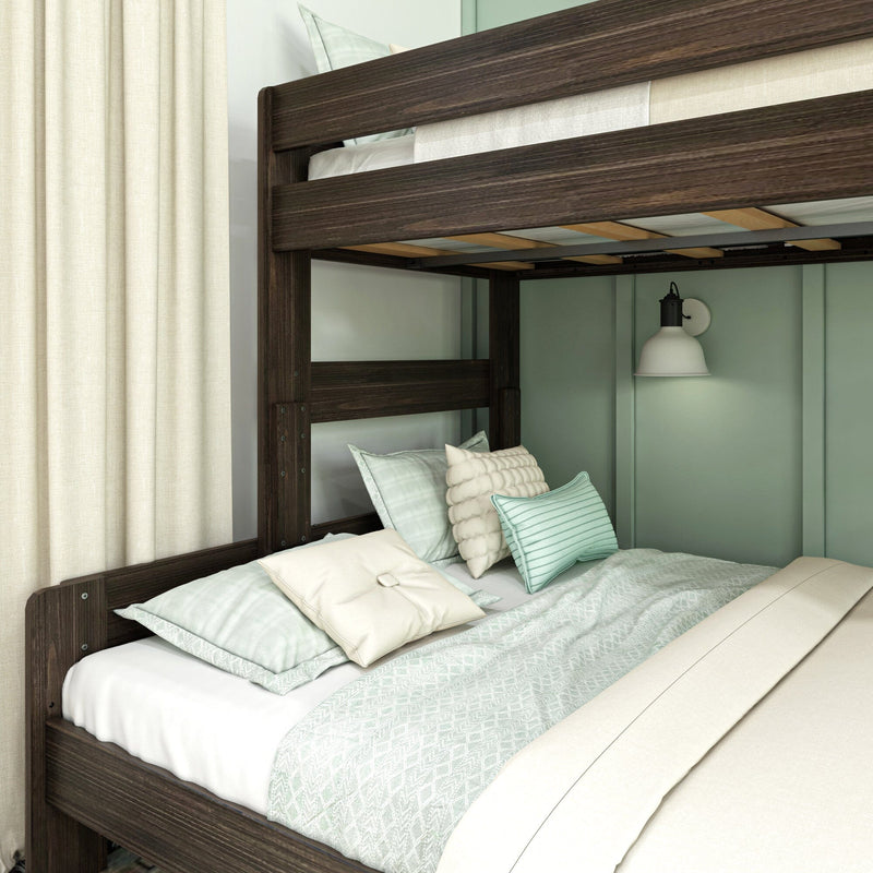 Dark wood bunk bed close-up with mint green bedding, decorative pillows, wall sconce and cream curtains