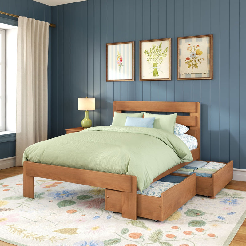 Wooden platform bed with storage drawers, light green bedding, navy blue paneled wall, framed floral prints, bedside lamp and floral area rug
