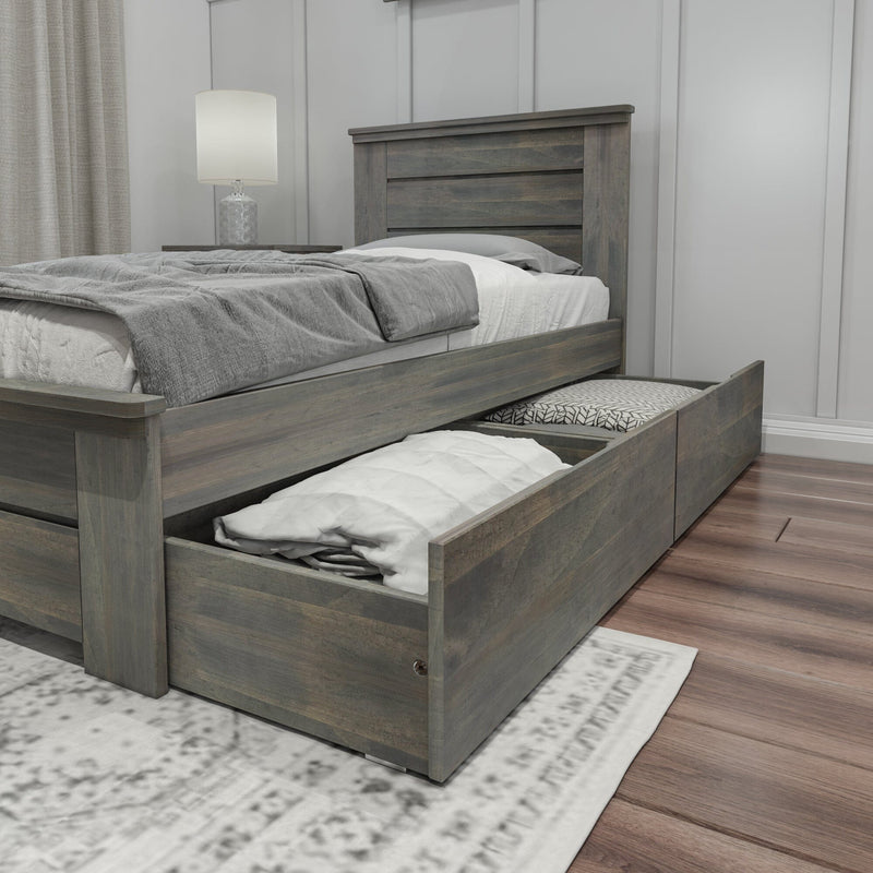 Gray wooden storage bed with pull-out under-bed drawers, soft gray bedding and bedside lamp in a modern farmhouse bedroom