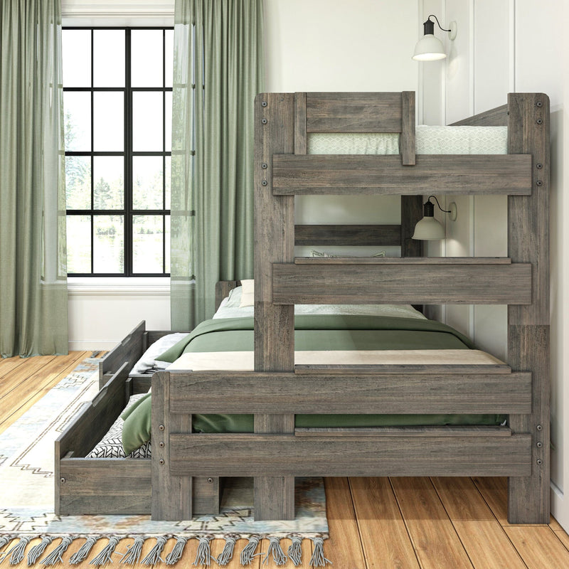Rustic gray wooden bunk bed with green bedding and under-bed storage trundle in a sunlit modern farmhouse kids bedroom featuring a large black-framed window, light green curtains, hardwood floor, and wall-mounted reading lamp