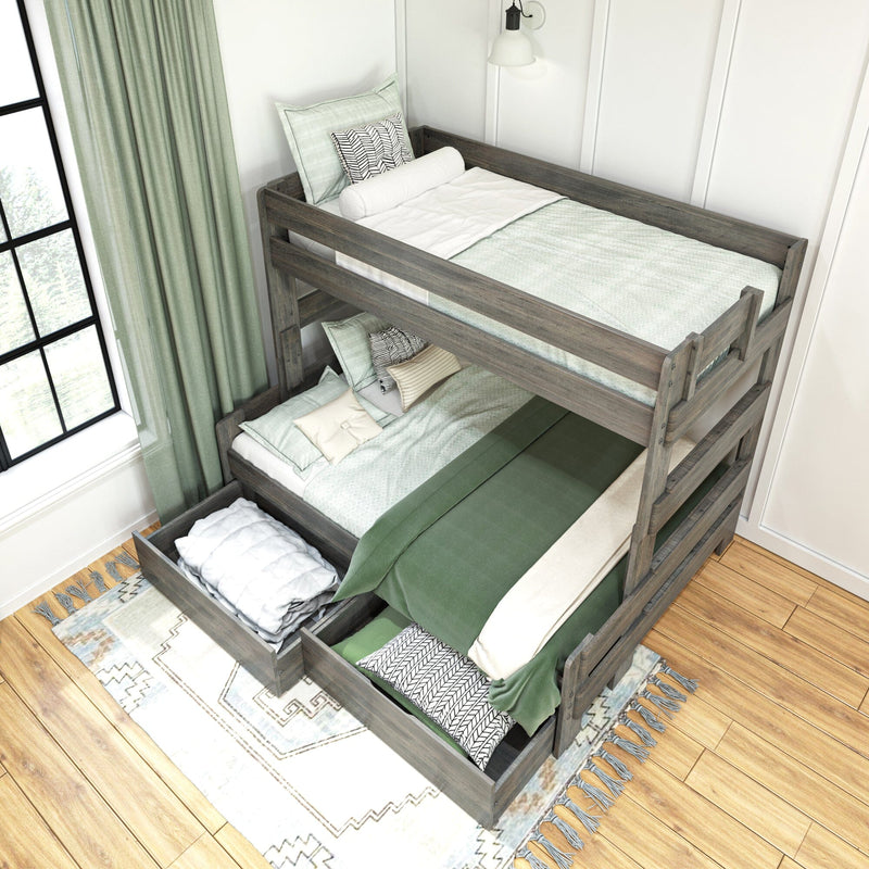Rustic gray wooden twin bunk bed with green bedding, patterned pillows and under-bed storage drawers in a bright farmhouse bedroom with window and curtains