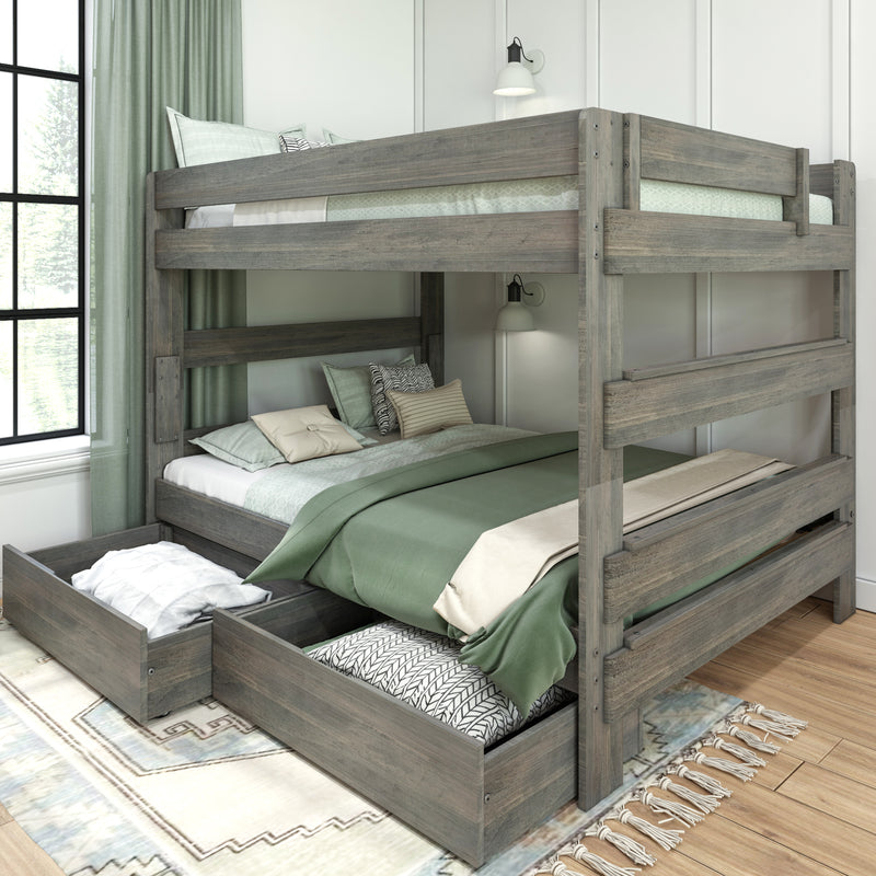 Rustic gray wooden twin-over-twin bunk bed with pull-out trundle storage drawers, green bedding and pillows, wall sconces and large window in a modern bedroom