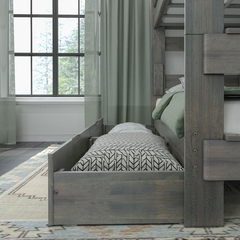 Gray wooden bunk bed with pull-out trundle, green bedding and patterned pillow by window with sheer curtains in a cozy bedroom