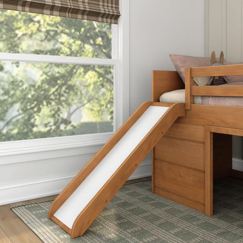 Children's wooden loft bed with slide in a neutral kids' bedroom, textured pillows and bunny plush, window with plaid Roman shade and blurred leafy backyard view
