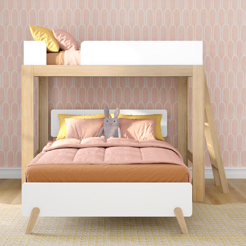 Scandinavian-style wooden loft bunk bed in a children's bedroom with pink bedding, yellow accent pillows, a stuffed bunny and pastel arch-pattern wallpaper