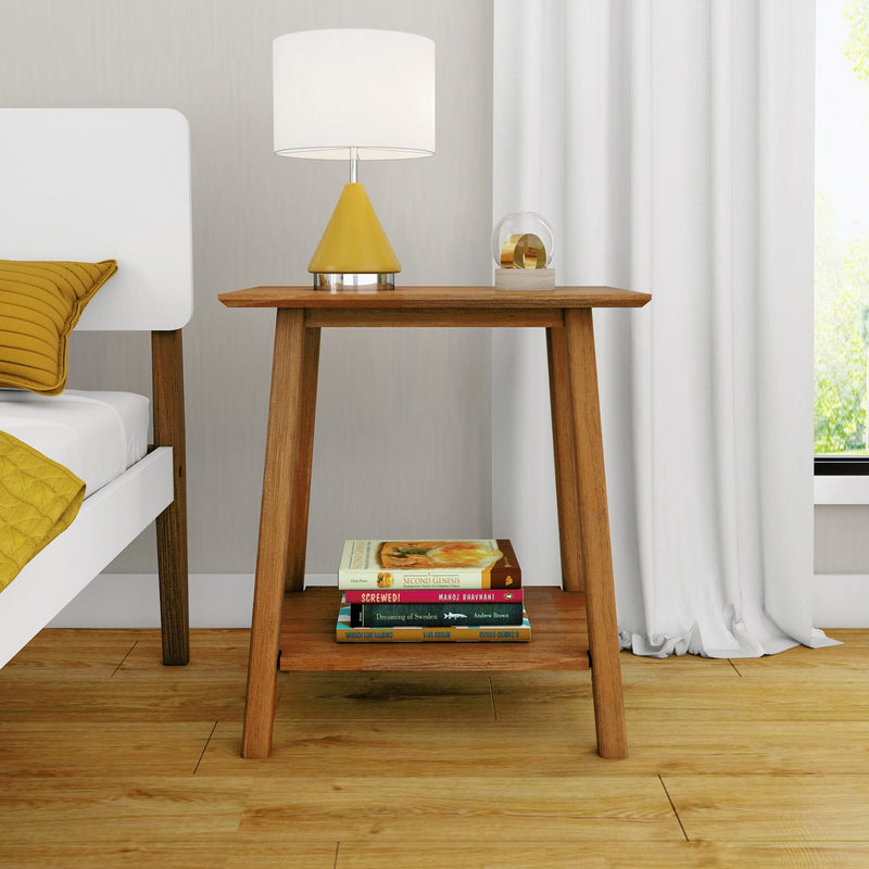 Modern wooden bedside table and nightstand decor with yellow cone table lamp, glass orb accent, stacked books and white bed with mustard yellow pillow in a minimalist bedroom
