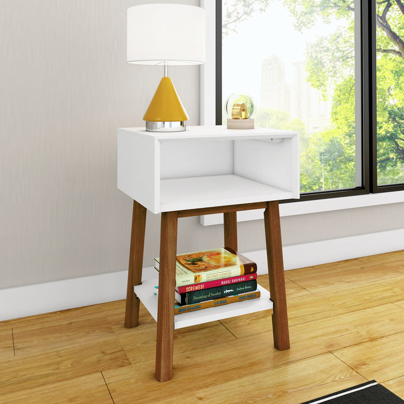 Minimalist bedside table with white open shelf and wooden legs, yellow cone table lamp, stacked books on lower shelf and window park view