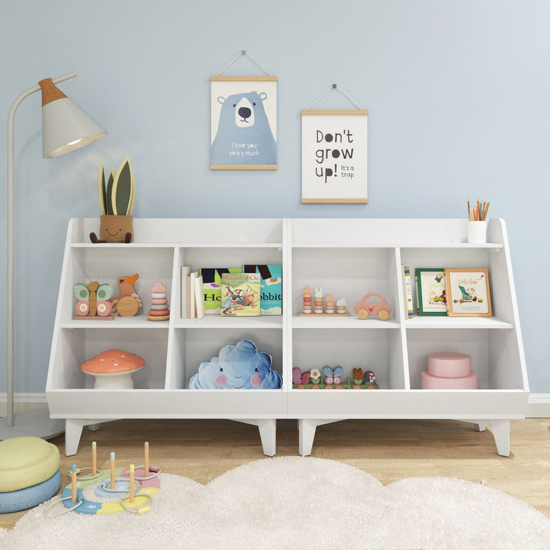 White children's bookshelf in pastel blue nursery with hanging bear and "Don't grow up" prints, wooden toys, stacking rings, children's books, plush cloud pillow and floor lamp
