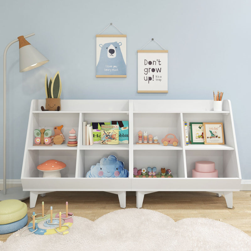 White children's bookshelf in pastel blue nursery with hanging bear and "Don't grow up" prints, wooden toys, stacking rings, children's books, plush cloud pillow and floor lamp