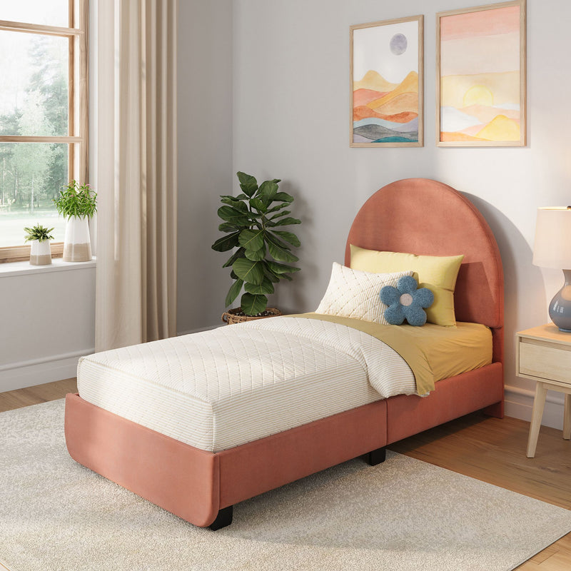 Modern cozy bedroom decor with coral upholstered bed, yellow bedding and quilted pillows, blue flower cushion, framed abstract landscape art, fiddle leaf fig plant and a window with beige curtains letting in soft natural light
