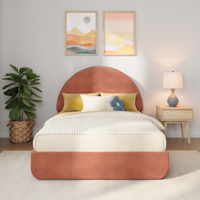 Modern bedroom decor with coral round headboard, neutral striped bedding, yellow accent pillows and blue flower cushion, wooden nightstand with lamp, woven basket fiddle leaf fig, and two framed abstract landscape prints