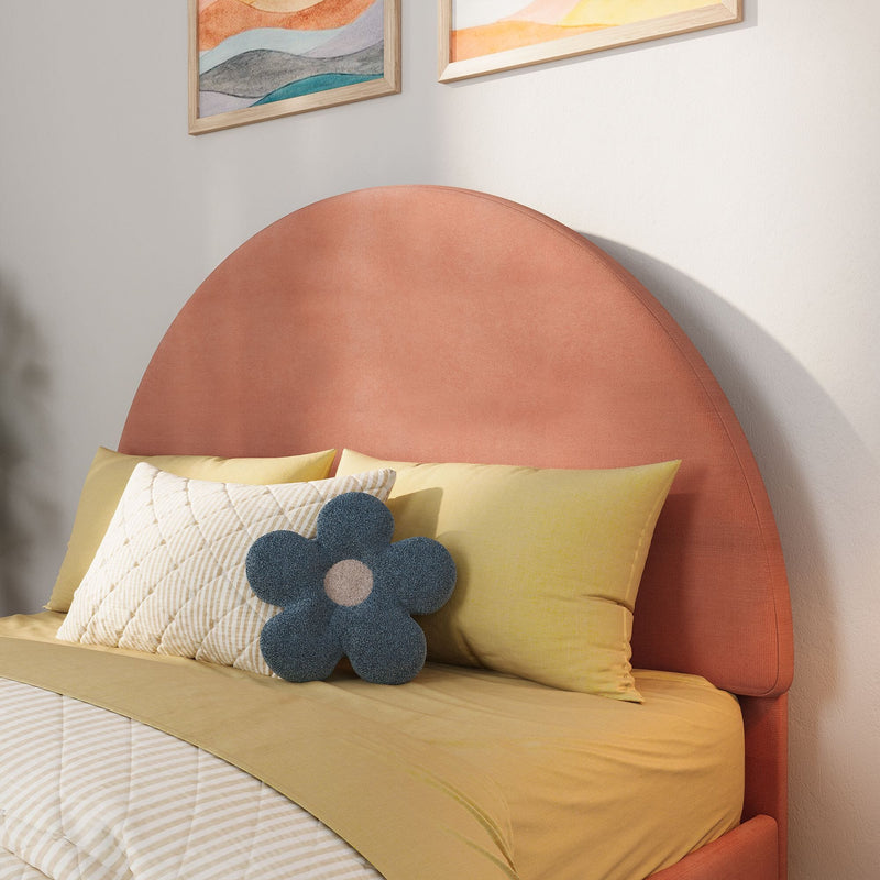 Coral pink round upholstered headboard with yellow bedding, quilted pillows and blue flower-shaped throw pillow in modern bedroom decor with abstract wall art