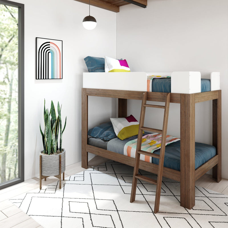 Modern wooden twin bunk bed in minimalist kids' bedroom with colorful pillows, geometric rug, framed rainbow art and potted snake plant