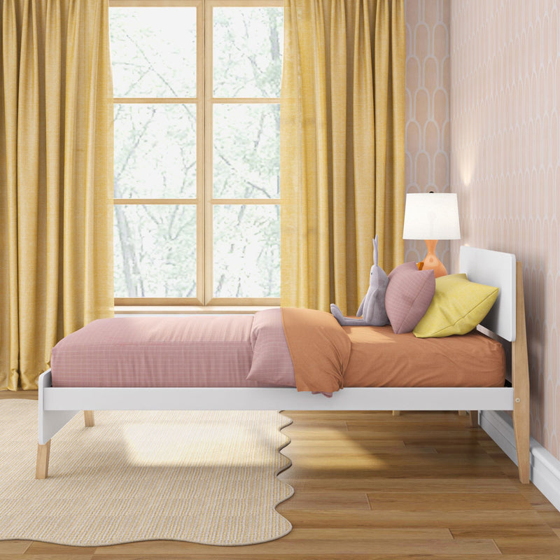 Cozy kids bedroom with pink bedding, yellow curtains, pastel geometric wallpaper, stuffed rabbit and bedside lamp