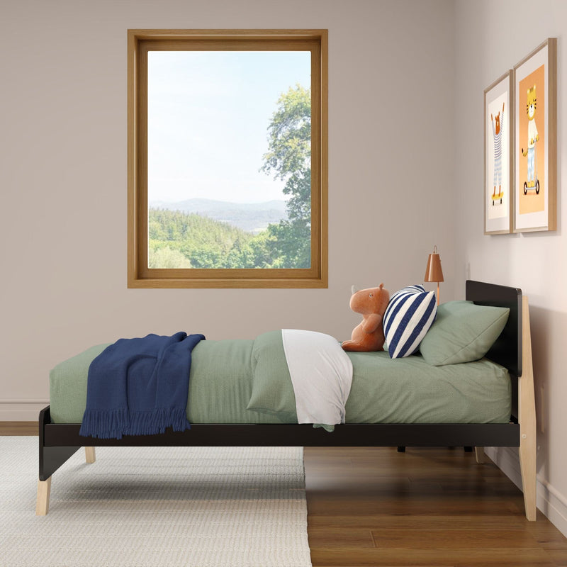 Modern children's bedroom with wooden-framed window overlooking forested hills, green single bed with striped pillow, plush teddy and framed nursery wall art