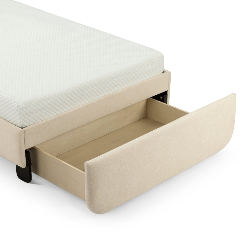 Beige upholstered storage bed with open under-bed wooden drawer and white quilted mattress corner on a modern platform frame