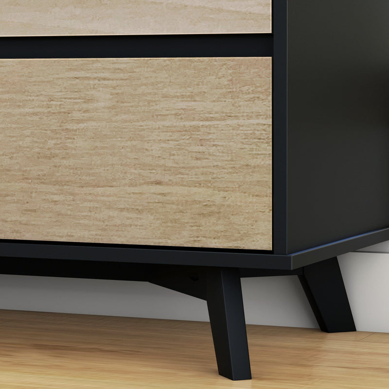 Close-up of modern mid-century dresser corner with light wood veneer drawers, matte black tapered legs and frame on hardwood floor