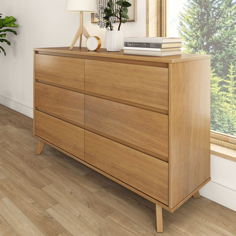 Mid-century modern oak dresser on hardwood floor by window, Scandinavian bedroom decor styled with tripod lamp, potted plant, gold clock and stacked books