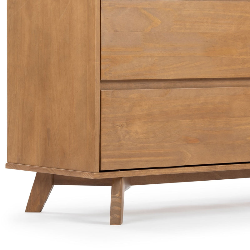 Close-up of a mid-century modern wooden dresser corner with tapered legs and natural oak wood grain, bedroom furniture detail