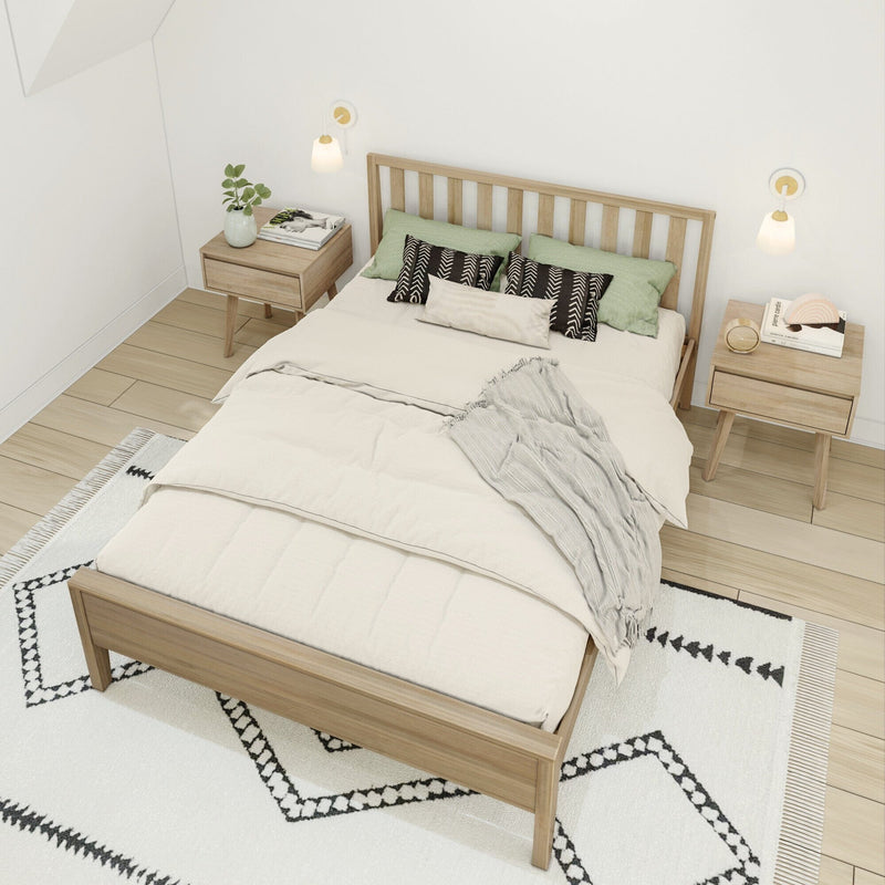 Minimalist Scandinavian bedroom interior with light wood platform bed, neutral beige bedding, green and patterned pillows, matching nightstands, wall sconces and geometric rug
