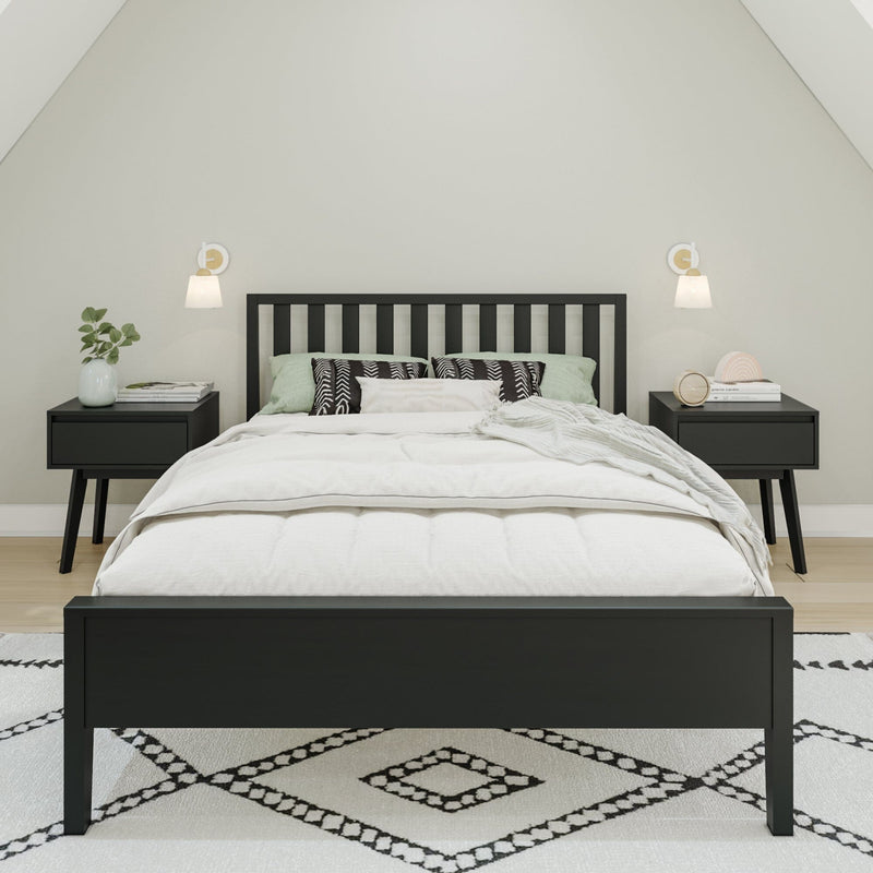 Modern minimalist bedroom with black slatted platform bed, white bedding, mint green pillows, matching black nightstands, wall sconces and geometric patterned rug