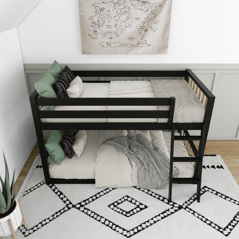 Black wooden bunk bed with ladder in a minimalist kids bedroom, neutral bedding, green throw pillows, world map wall art and black-and-white geometric rug