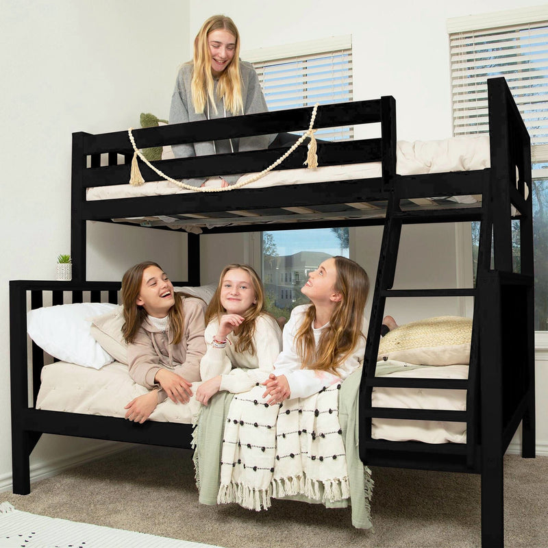 Four girls laughing on a black wooden twin-over-full bunk bed in a bright modern kids' bedroom with neutral bedding and ladder