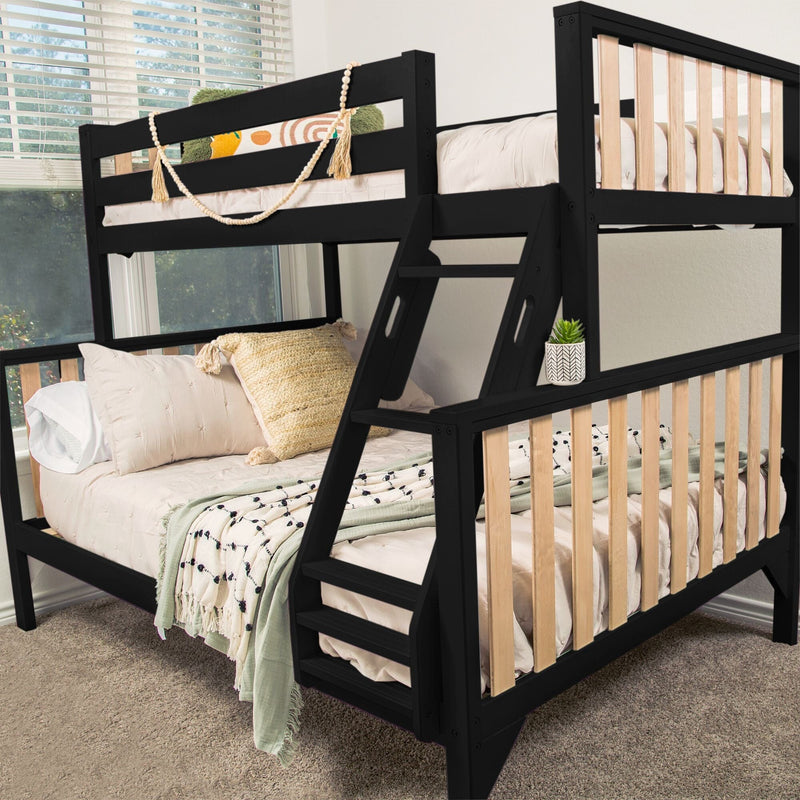 Black twin-over-full wooden bunk bed with angled ladder and natural wood slat rails, styled with neutral bedding, textured throw pillows and a potted succulent in a kids' bedroom