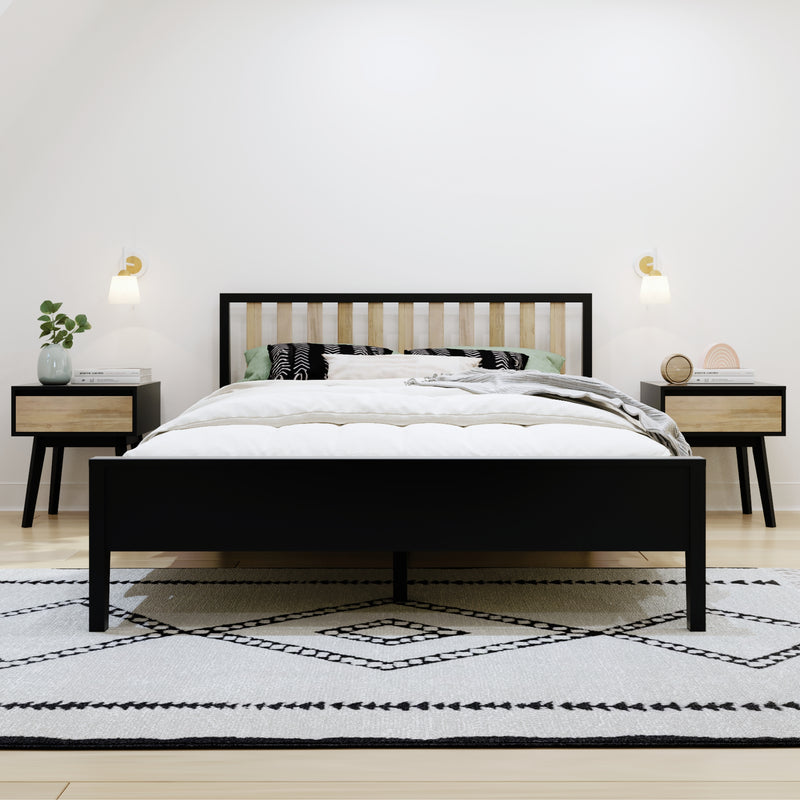 Modern minimalist bedroom with black bed frame and wooden slat headboard, white bedding, black-and-white patterned rug, bedside tables with lamps and potted plant