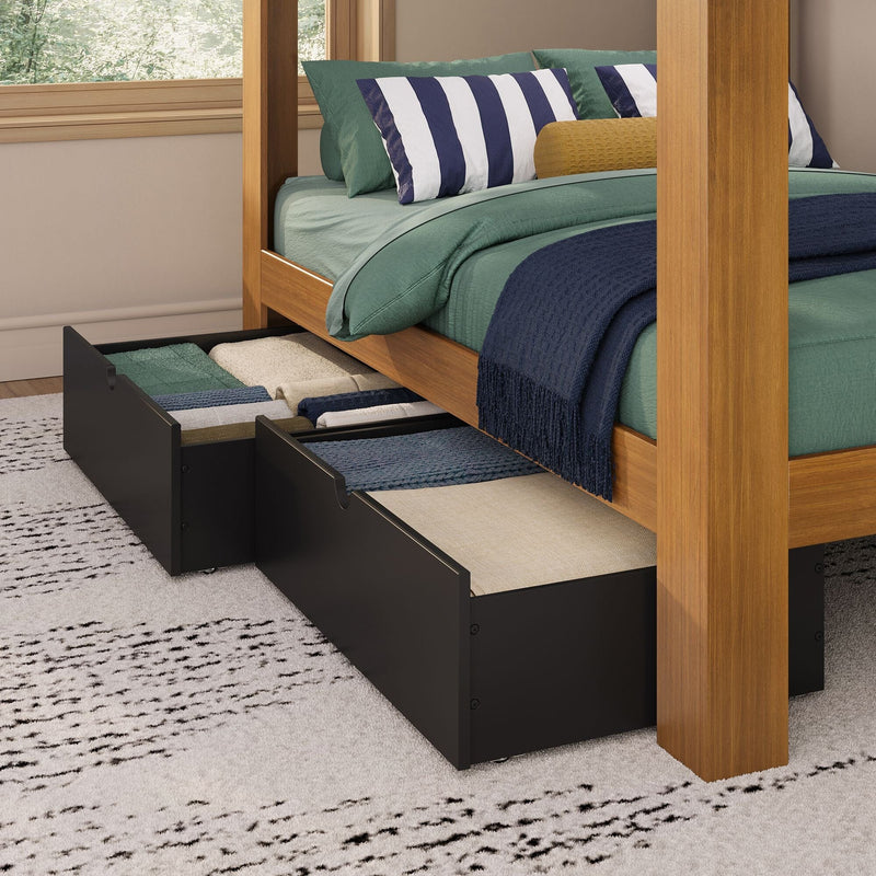 Under-bed storage drawers in a wooden four-poster bed with green bedding, navy-striped pillows and neatly folded linens
