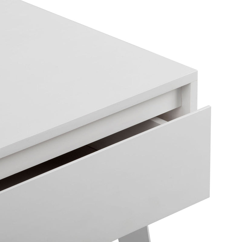 Close-up of a white modern handleless nightstand drawer showing minimalist bedside table design, matte finish and clean lines
