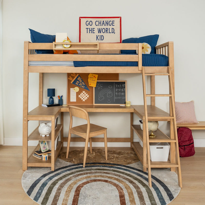 Wooden loft bed with built-in desk and ladder in a children's bedroom, navy blue bedding and pillows, study nook with corkboard and chalkboard, globe and piggy bank on shelves, and a motivational wall sign reading "Go Change The World, Kid
