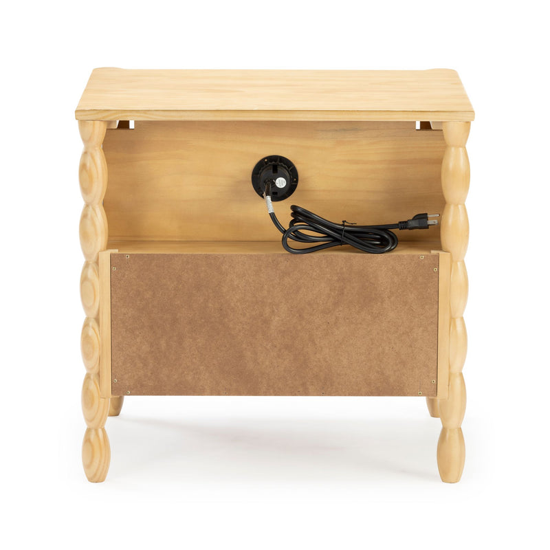 Back view of a light natural wood bedside table nightstand with turned legs, open shelf and integrated power outlet with coiled black cord and plug