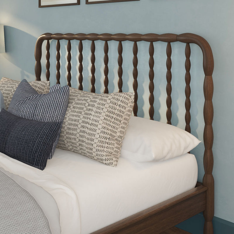 Wooden spindle headboard with white bedding and blue-gray textured pillows in a cozy farmhouse bedroom